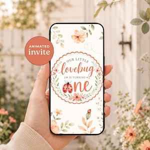 May include: A smartphone screen displaying a digital invitation with a white background, floral accents, and a ladybug illustration. The text reads: Our little lovebug is turning one. A circular scalloped frame surrounds the central text and ladybug.