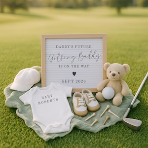 May include: A baby announcement with a golf theme. Includes a letter board with the text "Daddy's Future Golfing Buddy is on the Way Sept 2026", a white onesie, baby shoes, a teddy bear, a golf ball, a golf club, and golf tees.