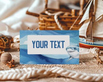 May include: A rectangular card featuring a watercolor-style blue ocean background with a shark illustration on the right side and a central white box containing the text YOUR TEXT in a bold, blue, sans-serif font.