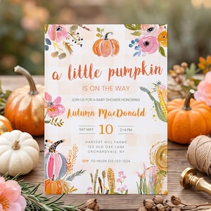 Puede incluir: Una tarjeta de invitación rectangular para baby shower con fondo de cuadros naranja claro e ilustraciones en acuarela de calabazas, flores rosas y trigo. El texto dice: a little pumpkin IS ON THE WAY, Autumn MacDonald, SAT MAY 10, 2-4 PM, HARVEST HILL FARMS, 123 OLD OAK LANE, ORCHARDVALE, NY, RSVP TO HELEN 123-123-1234.