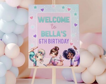 Puede incluir: Un letrero de bienvenida rectangular sobre un caballete de madera con el texto WELCOME to BELLA'S 6TH BIRTHDAY en color verde azulado y morado. El letrero tiene un fondo rosa claro con ilustraciones de tres jóvenes gimnastas, corazones y estrellas.