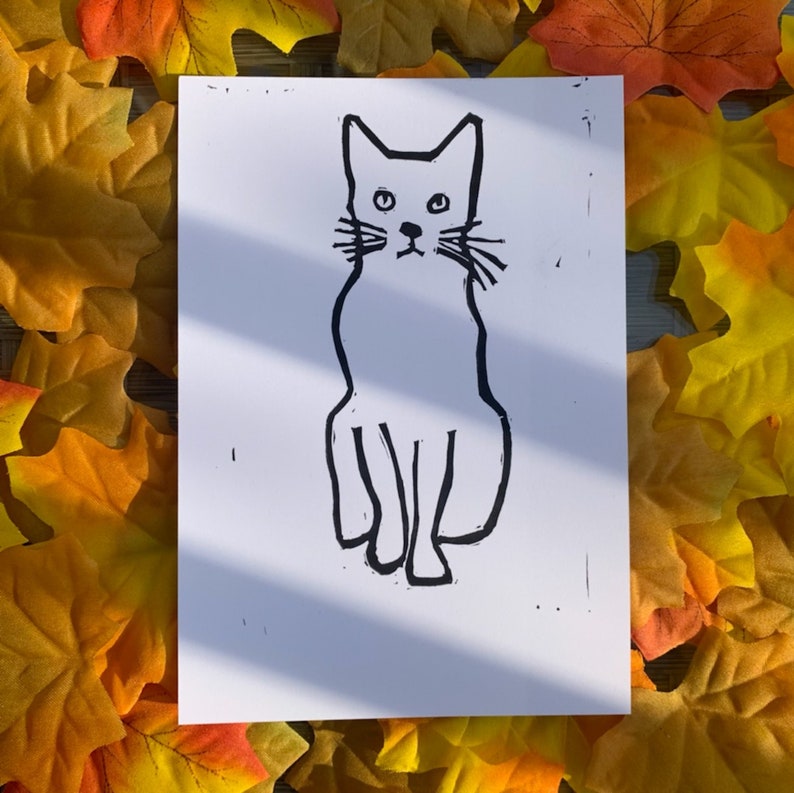 Pu&ograve; includere: Un disegno in bianco e nero di un gatto seduto su uno sfondo bianco.