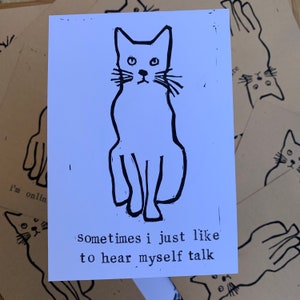 Pu&ograve; includere: Un'illustrazione in bianco e nero di un gatto seduto con il testo "sometimes I just like to hear myself talk" sotto.