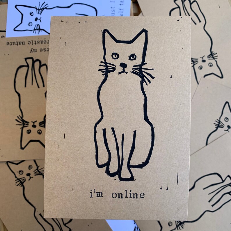 Pu&ograve; includere: Un biglietto marrone con un disegno a linea nera di un gatto seduto con il testo "i'm online" sotto.