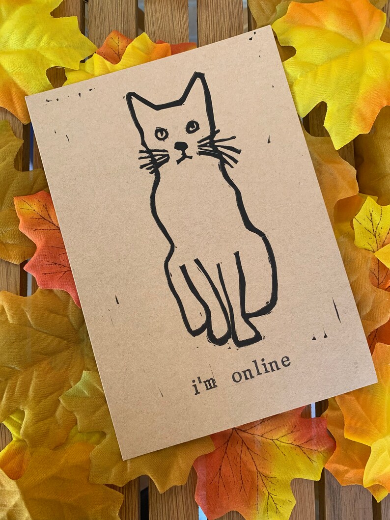Pu&ograve; includere: Un biglietto marrone con un disegno a linea nera di un gatto seduto con il testo "i'm online" sotto.