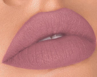 Puede incluir: Primer plano de los labios de una persona con un labial mate malva.