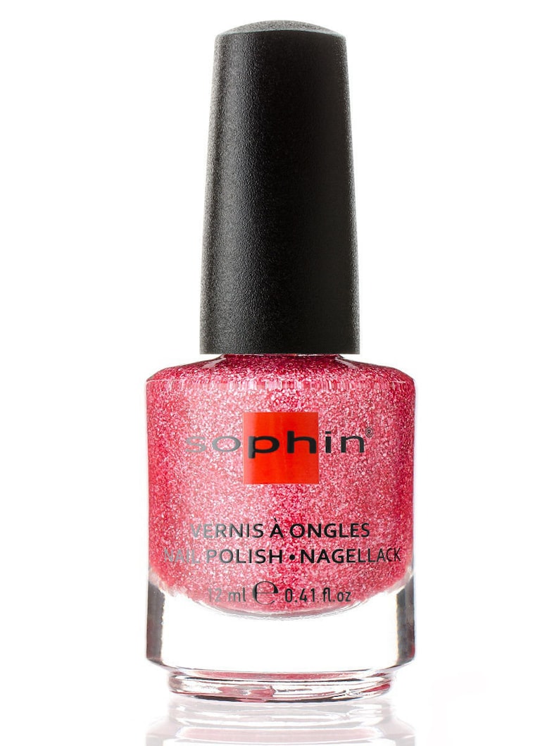 K&ouml;nnte beinhalten: Eine durchsichtige Glasflasche mit schwarzem Deckel von Sophiin Nagellack. Der Lack ist in einem glitzernden Rosaton. Das Etikett auf der Flasche lautet "Vernis &agrave; Ongles Nail Polish Nagellack 12 ml e 0.41 fl.oz."
