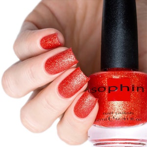 Puede incluir: Una botella de esmalte de uñas rojo con tapa negra y acabado de brillo dorado. La botella está etiquetada con "Sophin" y "esmalte de uñas". La botella es de 12 ml o 0,41 fl. oz.