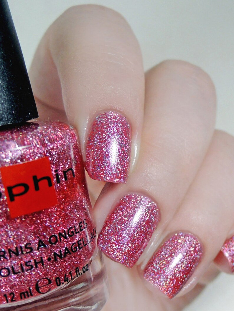 K&ouml;nnte beinhalten: Rosafarbener Nagellack mit Glitzerfinish. Die Flasche ist mit "O.P.I. Vernis a Ongles Polish. Nagellack 12 ml e 0.4 fl. oz." beschriftet.