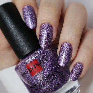 May include: A bottle of purple glitter nail polish with the brand name "Sophin" and the text "Vernis a Ongles All Polish Nail Gellack 12 ml 0.41 fl oz" on the label.