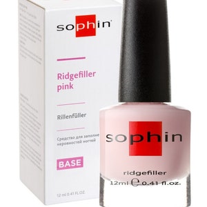 May include: A 12 ml bottle of pink ridge filler nail polish by Sophin. The bottle is clear and shows the pink polish inside. The label says "Ridgefiller pink" and "Base".