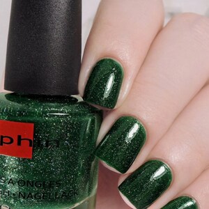 Puede incluir: Una botella de esmalte de u&ntilde;as verde con un acabado brillante. La botella est&aacute; etiquetada como "Sophin" y "Sa ongles - Nail Lacquer". La botella es de 0,41 fl oz. Se muestra una mano con cuatro u&ntilde;as pintadas con el esmalte de u&ntilde;as verde.