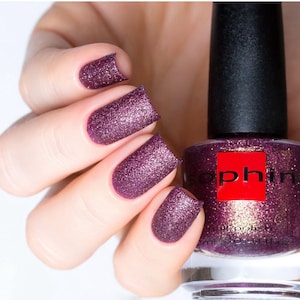 Puede incluir: Una botella de esmalte de uñas de color morado oscuro con un acabado brillante. La botella está etiquetada como "Sophin" y tiene una tapa negra.