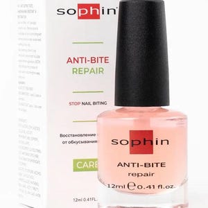 Puede incluir: Botella de tratamiento de uñas Sophin Anti-Bite Repair. La botella transparente contiene un líquido rosa pálido y tiene una tapa negra. El producto es de 12 ml. Una caja blanca con el logotipo de Sophin y la información del producto está detrás.