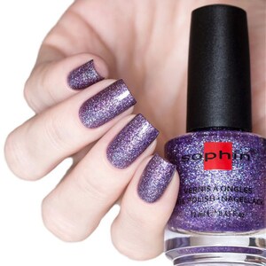 May include: A bottle of purple nail polish with a silver glitter finish. The bottle is labeled "Sophin" and "Vernis a Ongles Nail Polish Nagellack".