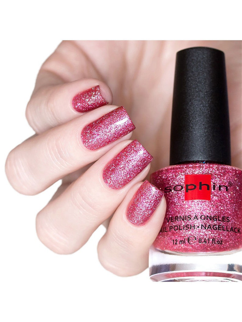 K&ouml;nnte beinhalten: Eine Flasche rosa Glitzer-Nagellack mit dem Markennamen "Sophin" auf dem Etikett. Die Flasche ist 12 ml (0.47 fl oz) gro&szlig;.