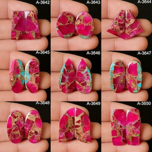 Könnte beinhalten: Eine Sammlung von Edelstein-Cabochons in verschiedenen Formen, darunter oval, tropfenförmig und rechteckig. Die Steine weisen einen leuchtenden rosa Farbton mit goldenen und türkisfarbenen Akzenten auf. Jeder Stein hat ein einzigartiges Mosaikmuster.