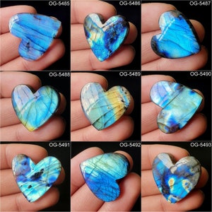 May include: Nine heart-shaped labradorite gemstones with iridescent blue, green, and gold colors. The stones are polished and have a smooth, glossy finish.