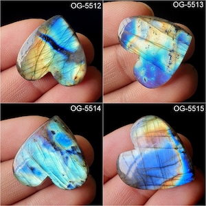May include: Four heart-shaped labradorite gemstones with iridescent blue, green, and gold colours. The stones are labelled with the codes OG-5512, OG-5513, OG-5514, and OG-5515.