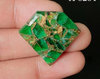 May include: A diamond-shaped gemstone featuring a mosaic of vibrant green fragments interspersed with metallic gold-colored veins. The stone displays a polished, reflective surface with a complex, fractured pattern. The text A-8284 is visible.