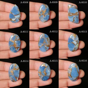May include: A collection of nine blue and copper-colored cabochons labeled A-8508 through A-8516. Each polished gemstone features a light blue base with intricate, branching metallic copper veins in various oval and teardrop shapes.