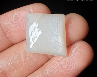 May include: A translucent, off-white, kite-shaped gemstone with a smooth, polished surface and a reflective sheen. The stone features a distinct, irregular white inclusion on its left side and is labeled with the text A-9041 in the corner.