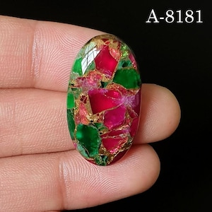 May include: An oval-shaped cabochon gemstone featuring a vibrant mosaic pattern of deep magenta and emerald green segments separated by thin, metallic copper-colored veins. The text A-8181 is visible in the upper right corner of the image.