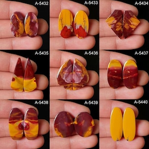 Op de afbeelding: Een verzameling van negen paren gepolijste edelsteen cabochons in verschillende vormen. De stenen hebben een mix van kleuren, waaronder geel, rood en bruin. Elk paar wordt in een hand gehouden, waarbij de unieke patronen en tinten van de natuurlijke materialen worden getoond.