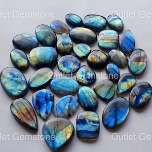 May include: A collection of 20 labradorite gemstone cabochons in various shapes and sizes. The stones are a mix of blue, green, and gold colours with iridescent flashes.
