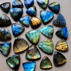 Puede incluir: Una colección de piedras preciosas de labradorita triangulares. Las piedras muestran una gama de colores, incluyendo azules, verdes y dorados, con destellos iridiscentes. Cada piedra está pulida y tiene una superficie lisa, mostrando patrones naturales.