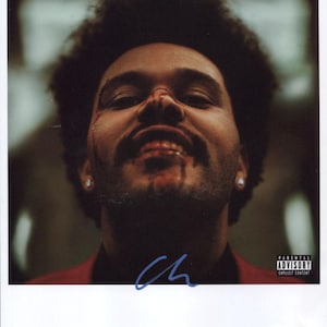 Puede incluir: Un retrato de cerca de un hombre con cabello oscuro y barba. Lleva una chaqueta roja y tiene sangre en la cara. La imagen tiene una etiqueta de advertencia para padres con el texto "Parental Advisory Explicit Content".