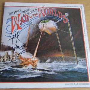 Könnte beinhalten: Albumcover für Jeff Waynes Musical Version of The War of the Worlds. Das Artwork zeigt eine marsianische Kriegsmaschine, die ein Schiff auf See angreift. Das Albumcover ist von Jeff Wayne signiert.