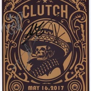 May include: A brown and gold concert poster for Clutch, featuring a skull in a sombrero smoking a cigar. The poster includes the band's name, tour details, and the date "May 16, 2017". The text reads "Psychic Warfare Tour" and "Lupo's Heartbreak Hotel".