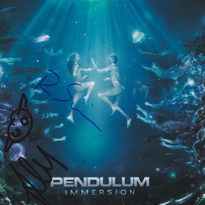 Peut inclure: Affiche représentant deux personnages sous l'eau, éclairés par des rayons de lumière. Le mot "PENDULUM" est au-dessus de "IMMERSION" en texte blanc. La scène comprend la vie marine et une palette de couleurs bleu foncé et sarcelle.