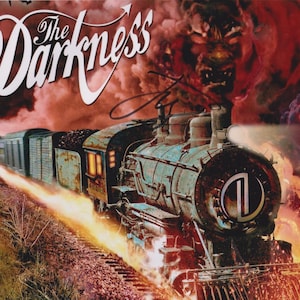 May include: A vintage steam train illustration with the title "The Darkness" in white script. The train is depicted with flames and smoke against a fiery red backdrop, with a monster figure emerging from the smoke.