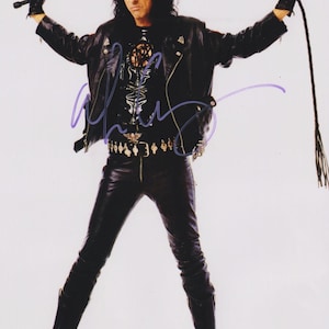 Puede incluir: Una persona con chaqueta, pantalones y botas de cuero negro, sosteniendo un látigo. El atuendo incluye un cinturón con tachuelas y una parte superior detallada. La imagen tiene una firma en la esquina inferior izquierda.