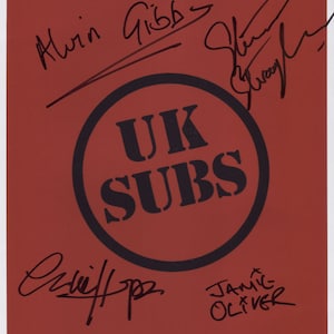 Puede incluir: Un fondo rojo con un círculo negro que contiene el texto "UK SUBS". Hay cinco firmas en tinta negra: "Alvin Gibbs", "Jamie Oliver", "Cliff", "Steve" y "Gwen".