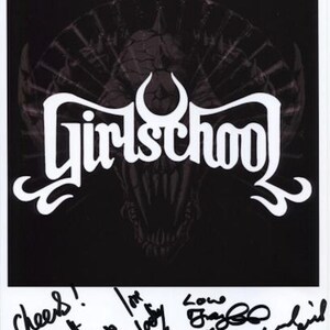 以下が含まれることがあります： 「Girlschool」というバンドの白黒写真で、頭蓋骨のグラフィックが描かれている。写真はバンドメンバーによってサインされている: 「Cheers! Love Kim, Love Kelly, Love Enza, Love Gil, Love Chris」