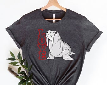 Peut inclure: Un t-shirt gris foncé avec un dessin de morse et le mot "LOVE" en rouge.