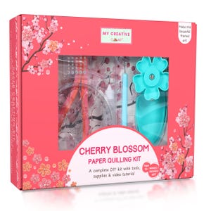 Könnte beinhalten: Eine rosa Schachtel mit einem Papier-Quilling-Kit. Das Set enthält Werkzeuge, Zubehör und ein Video-Tutorial. Die Schachtel ist mit Kirschblüten-Illustrationen und dem Text "CHERRY BLOSSOM PAPER QUILLING KIT" verziert.