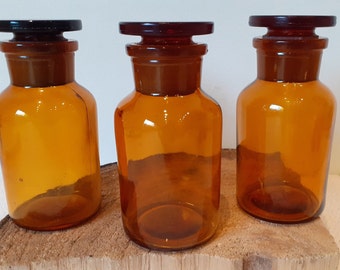 Ensemble de deux ou trois belles bouteilles d'apothicaire en verre avec cloche en verre, verre transparent ambré, 12 cm / 4,72 pouces de haut, années 1950