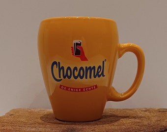 Chocomel, één mok , set van twee of drie gele mokjes van het Nederlandse chocolademelkmerk, logo van het handje met het glas chocomel