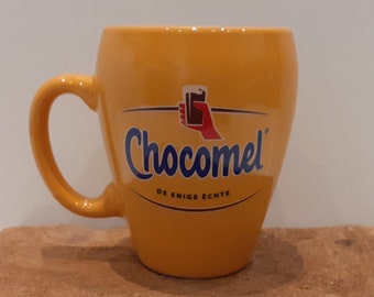 Chocomel, enkel linkshandig! geel mokje, met een gouden randje rond het logo van het handje met het glas Chocomel