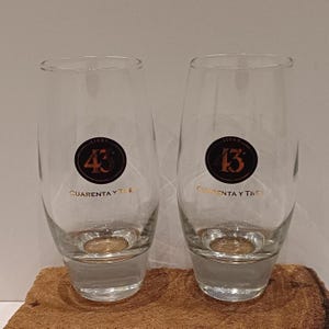 Licor 43, ein Glas oder Set aus zwei hohen Licor 43 Cuarenta y Tres Gläsern, dicker, stabiler Boden, das bekannte Logo auf einer Seite, in Schwarz und Gold