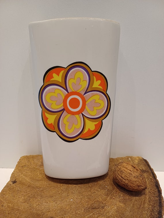 Una bandeja de radiador de cerámica, humidificador, evaporador de agua, con  una imagen de una flor retro de color naranja, amarillo y morado, años 70.  -  España