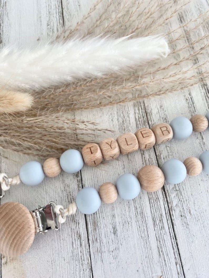 May include: A light blue and natural wood baby teether with the name 'Tyler' spelled out in wooden beads. The teether is attached to a clip for easy attachment to clothing. Personalized Pacifier Clip / Custom Baby Name / Personalized Baby Gift / Baby Shower gift /last minute gift / Newborn gift / Boho baby