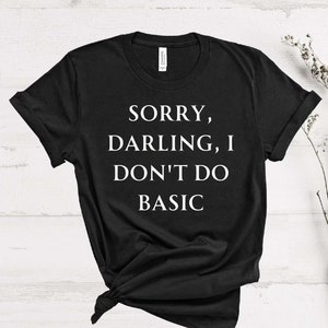 May include: Black t-shirt with white text that reads "Sorry, Darling, I Don't Do Basic".