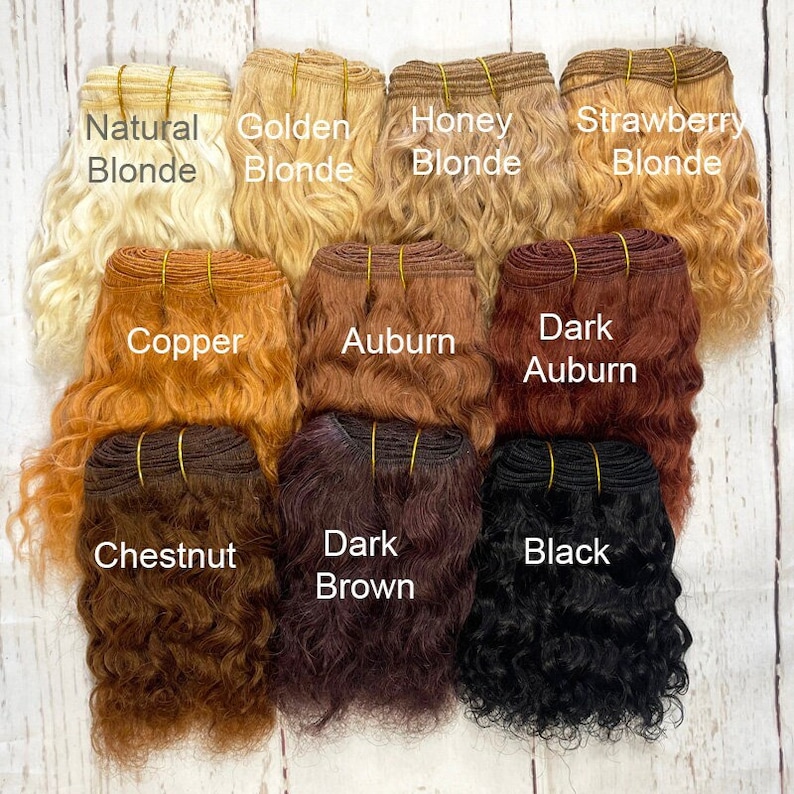 May include: A set of ten hair wefts in various shades of blonde, copper, auburn, chestnut, brown, and black. The wefts are labeled with their corresponding hair colors: Natural Blonde, Golden Blonde, Honey Blonde, Strawberry Blonde, Copper, Auburn, Dark Auburn, Chestnut, Dark Brown, and Black.