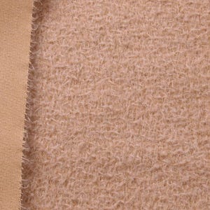 Puede incluir: Primer plano de dos texturas de tela. A la izquierda, una tela lisa y beige con un tejido fino. A la derecha, una tela marrón claro y difusa con una textura peluda. Las telas están una al lado de la otra.