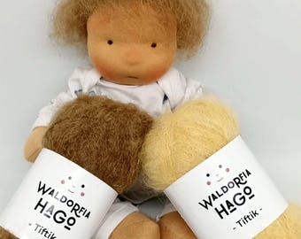 Könnte beinhalten: Zwei Knäuel Garn, eines braun und eines gelb, mit Etiketten mit der Aufschrift "Waldorfia Hago - Tiftik".